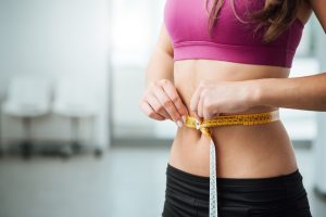 woman measuring her weight loss